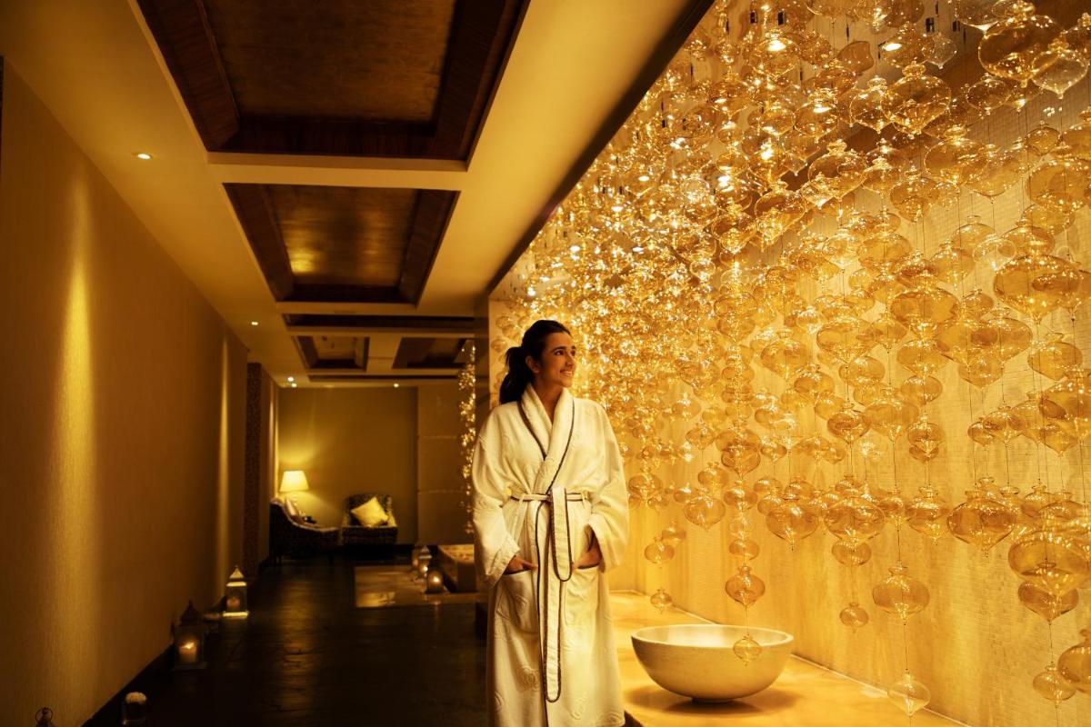 a woman in a robe standing in front of a wall at Sofitel Mumbai BKC in Mumbai