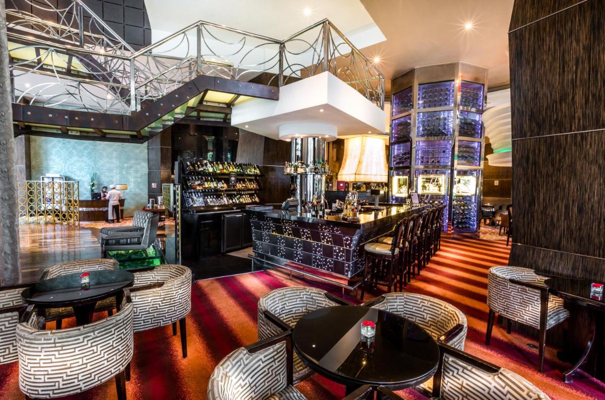 a restaurant with tables and chairs and a bar at Sofitel Mumbai BKC in Mumbai