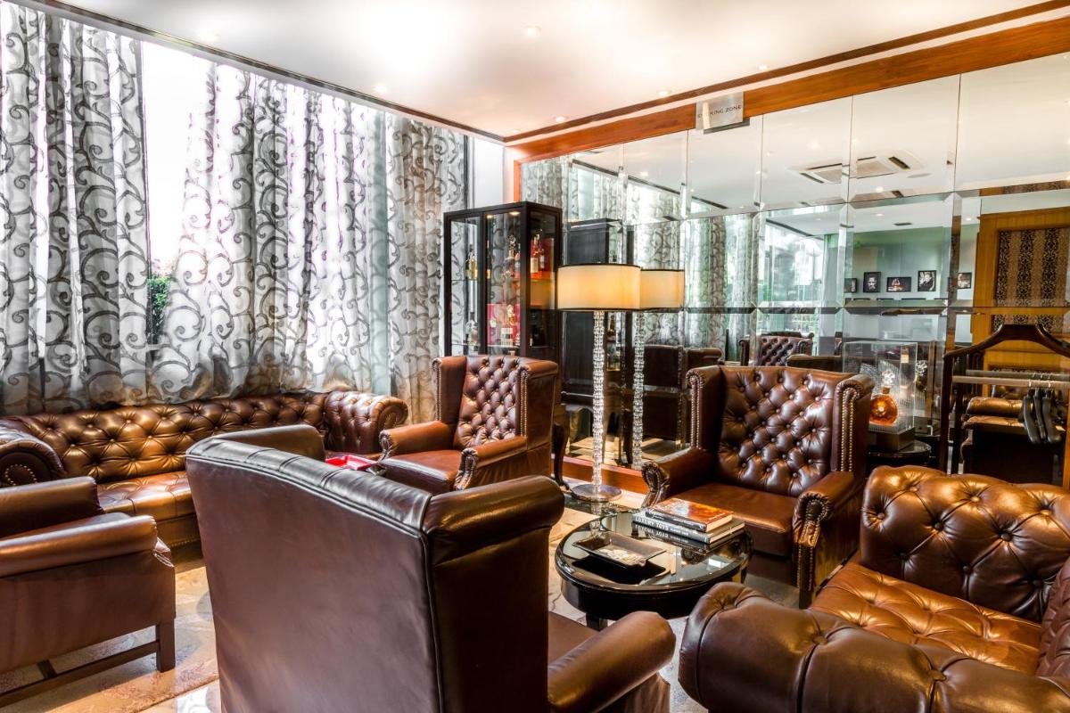 a barber shop with leather furniture and a mirror at Sofitel Mumbai BKC in Mumbai