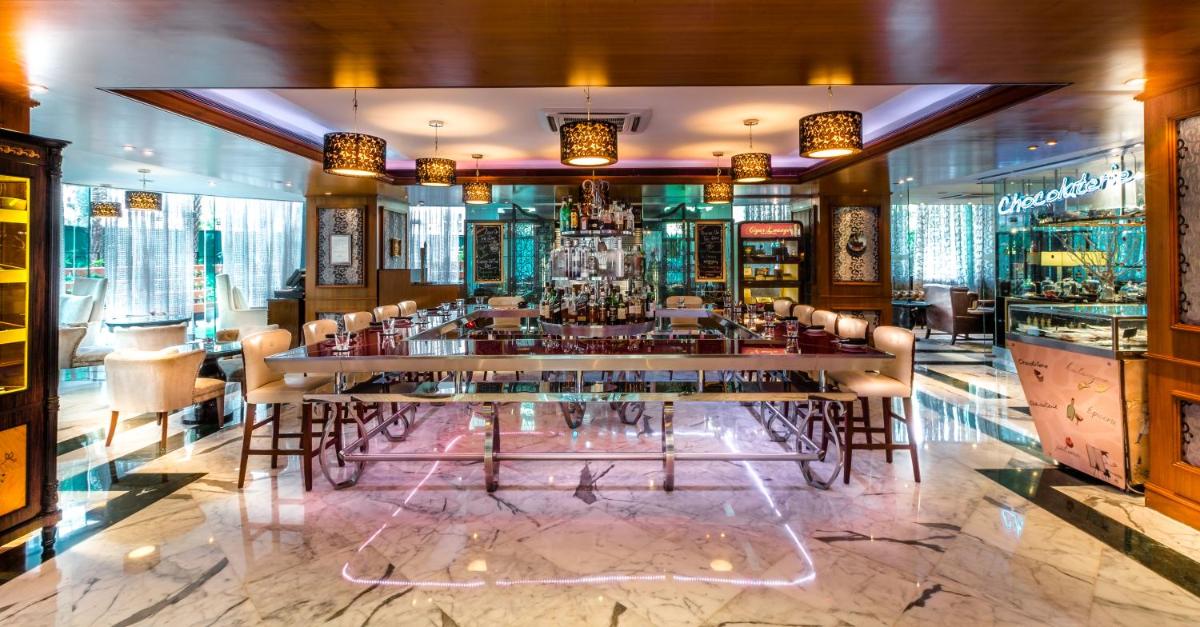 a bar in a restaurant with a table and chairs at Sofitel Mumbai BKC in Mumbai