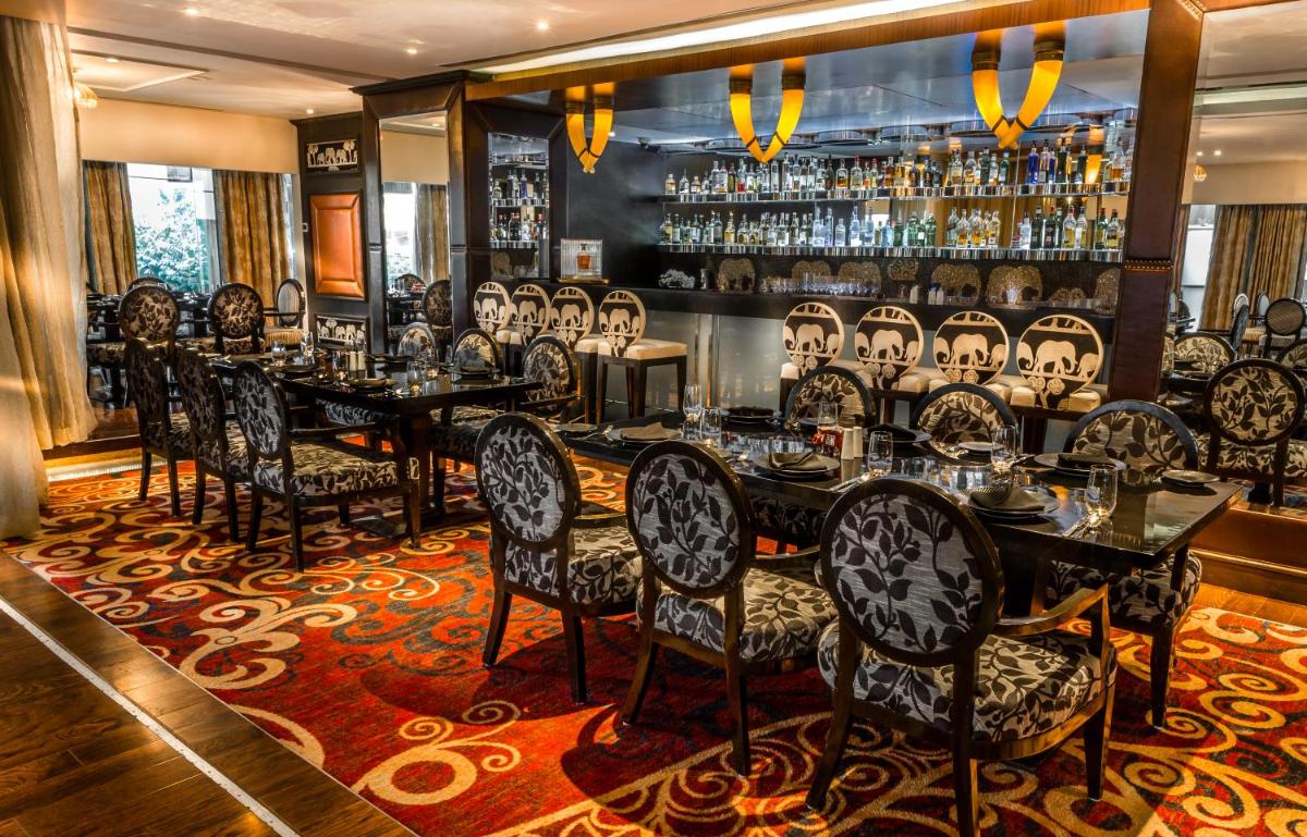 a dining room with tables and chairs and a bar at Sofitel Mumbai BKC in Mumbai