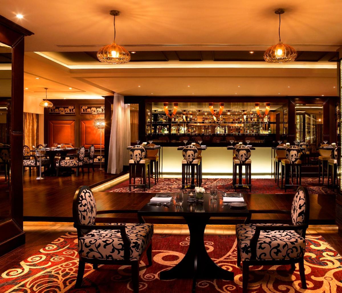 a restaurant with a table and chairs and a bar at Sofitel Mumbai BKC in Mumbai