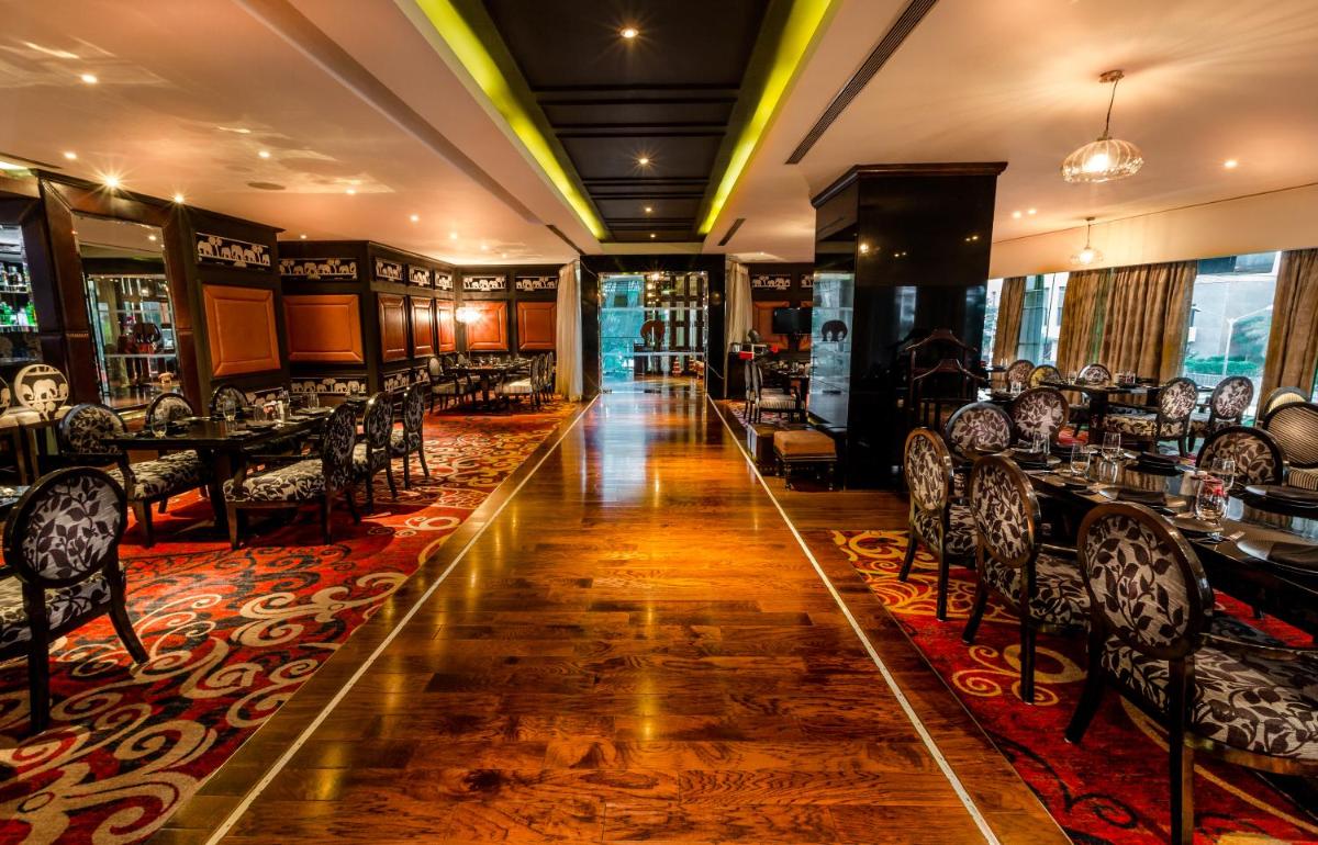a restaurant with tables and chairs in a room at Sofitel Mumbai BKC in Mumbai