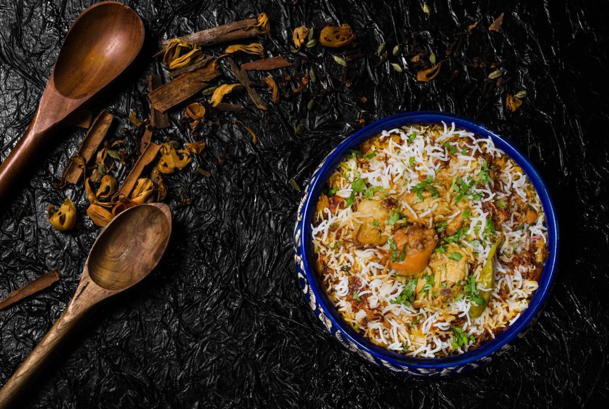 a bowl of rice with chicken and vegetables on a table at Sofitel Mumbai BKC in Mumbai