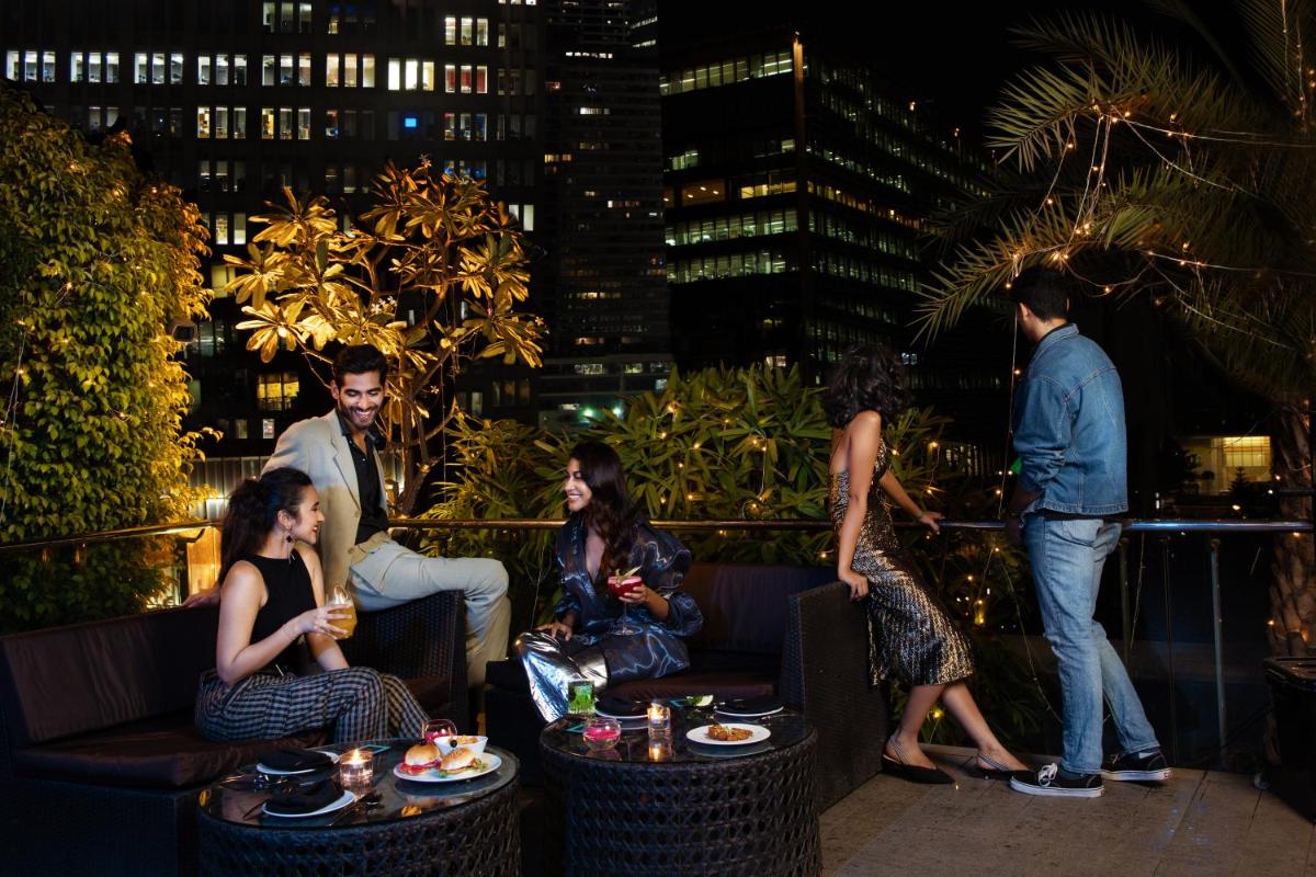 a group of people sitting on a patio at night at Sofitel Mumbai BKC in Mumbai
