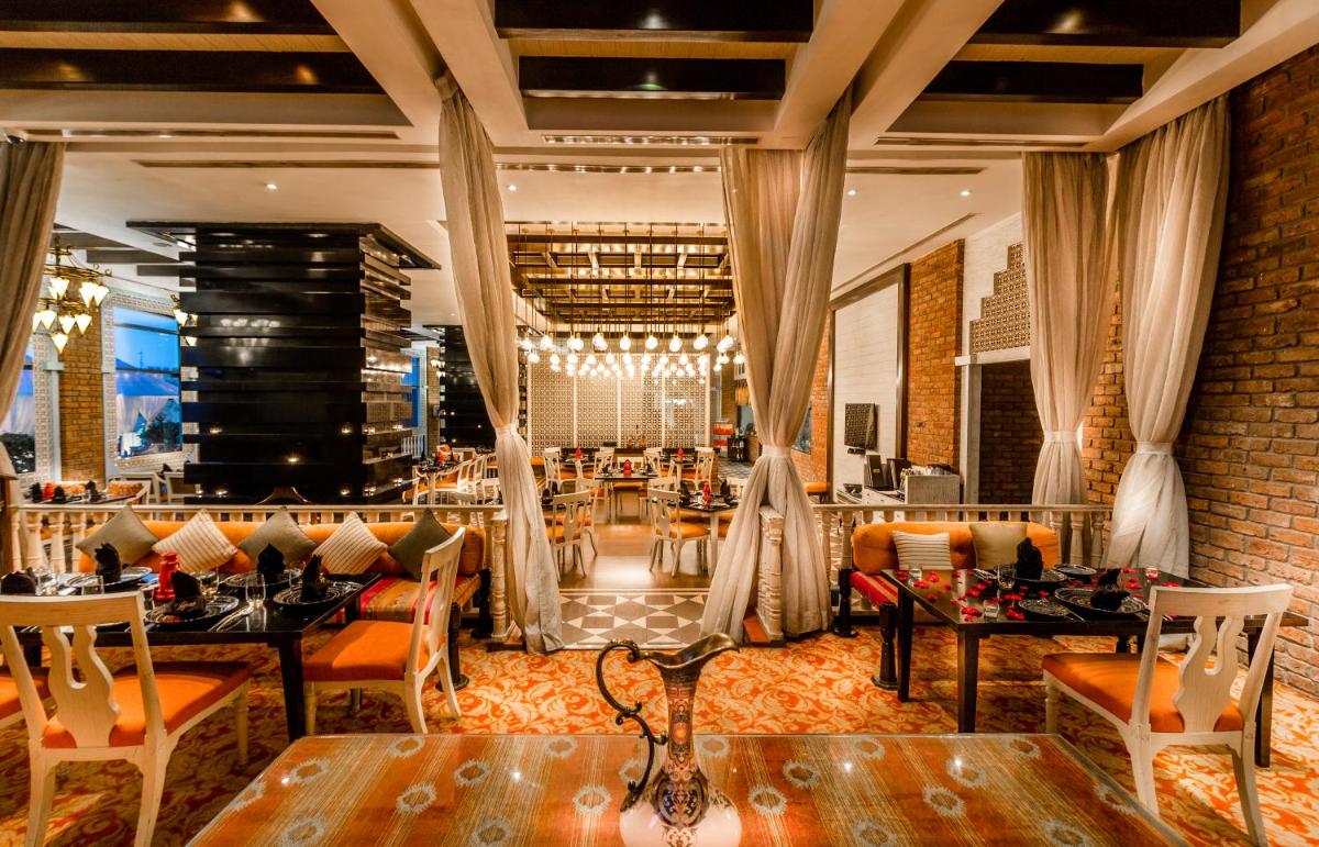 a restaurant with tables and chairs in a room at Sofitel Mumbai BKC in Mumbai