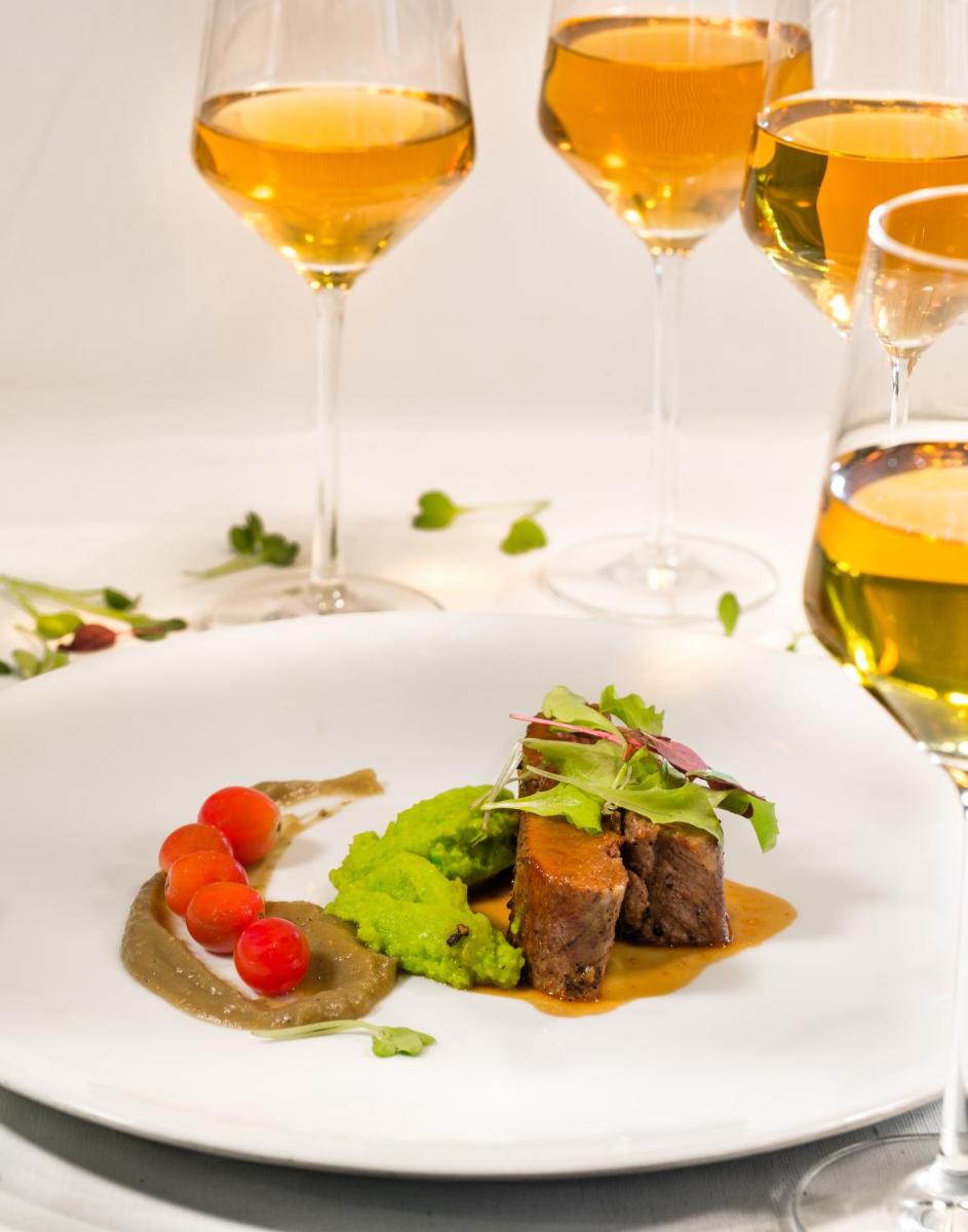 a plate of food on a table with wine glasses at Sofitel Mumbai BKC in Mumbai