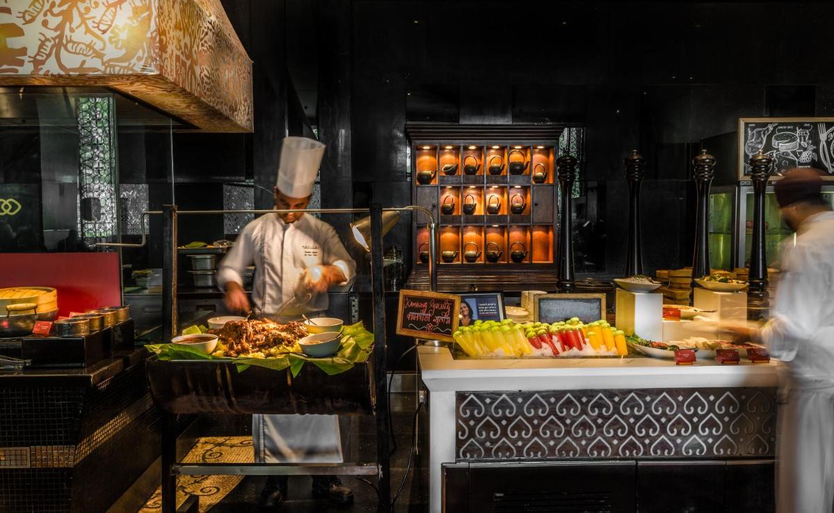 a chef preparing food in a restaurant kitchen at Sofitel Mumbai BKC in Mumbai