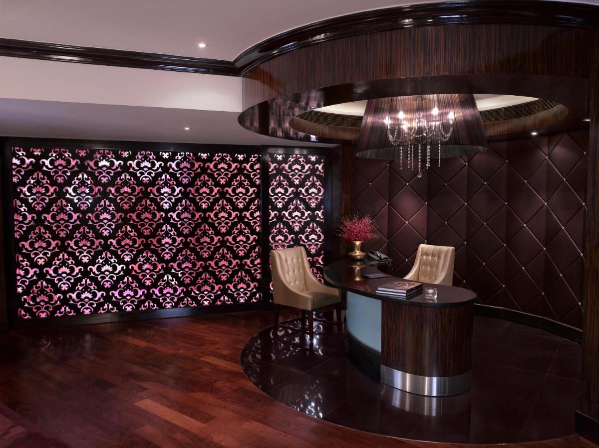 a lobby with a table and chairs and a wall covered in wallpaper at Sofitel Mumbai BKC in Mumbai