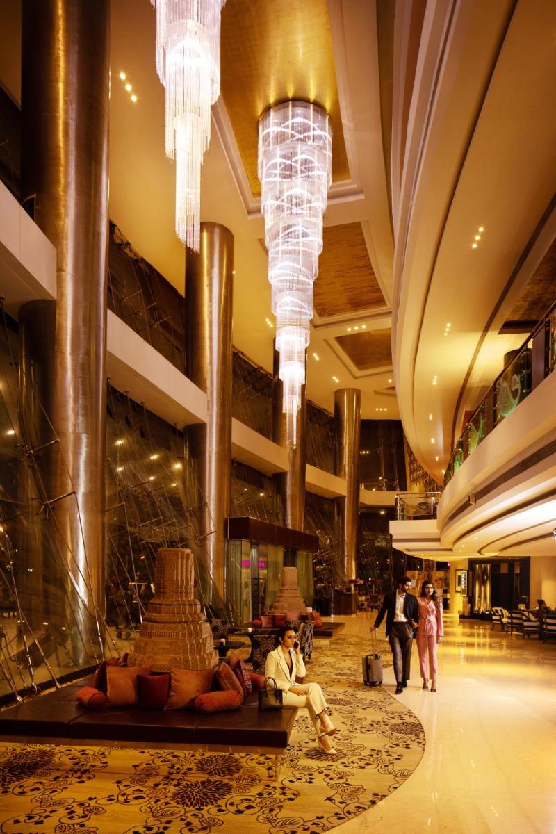 a lobby of a building with people walking in it at Sofitel Mumbai BKC in Mumbai