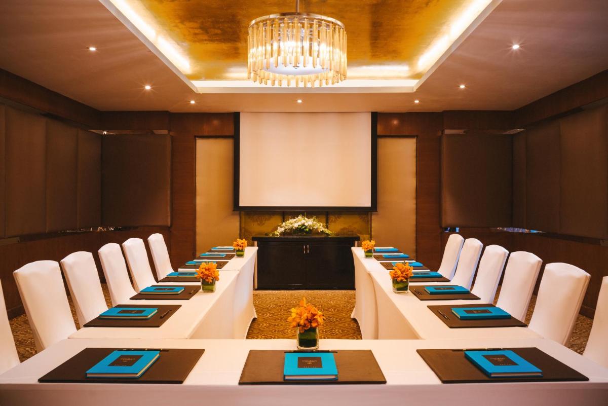 a long table in a room with chairs and a podium at Sofitel Mumbai BKC in Mumbai