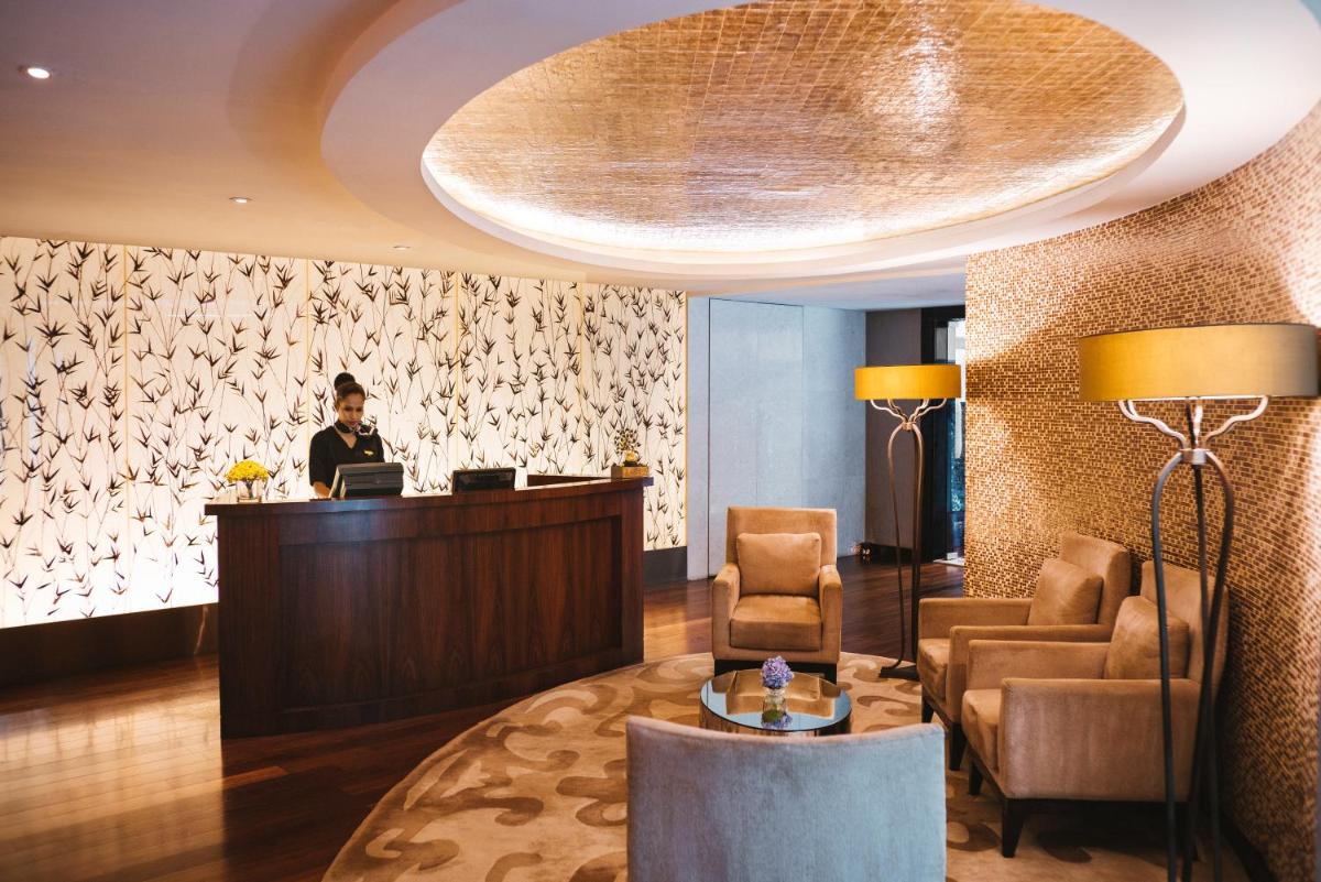 a woman standing at a reception desk in a hotel lobby at Sofitel Mumbai BKC in Mumbai