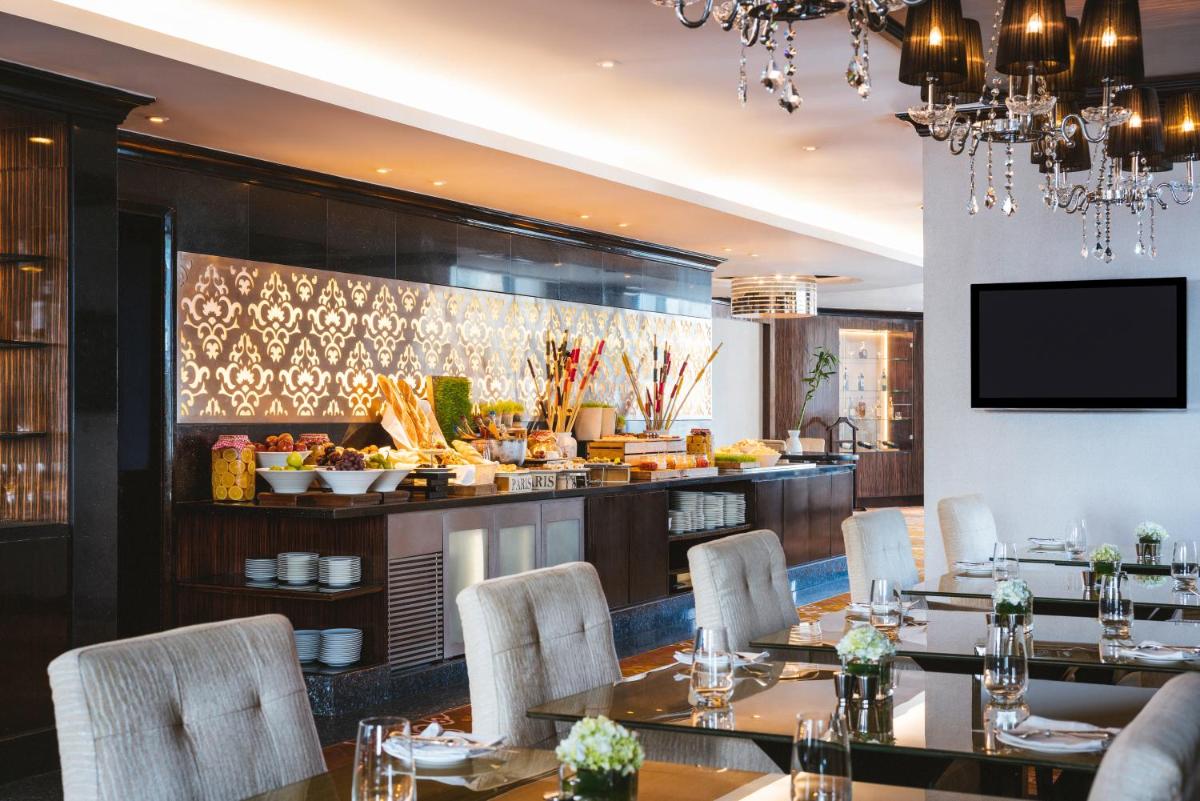 a restaurant with tables and chairs and a buffet at Sofitel Mumbai BKC in Mumbai