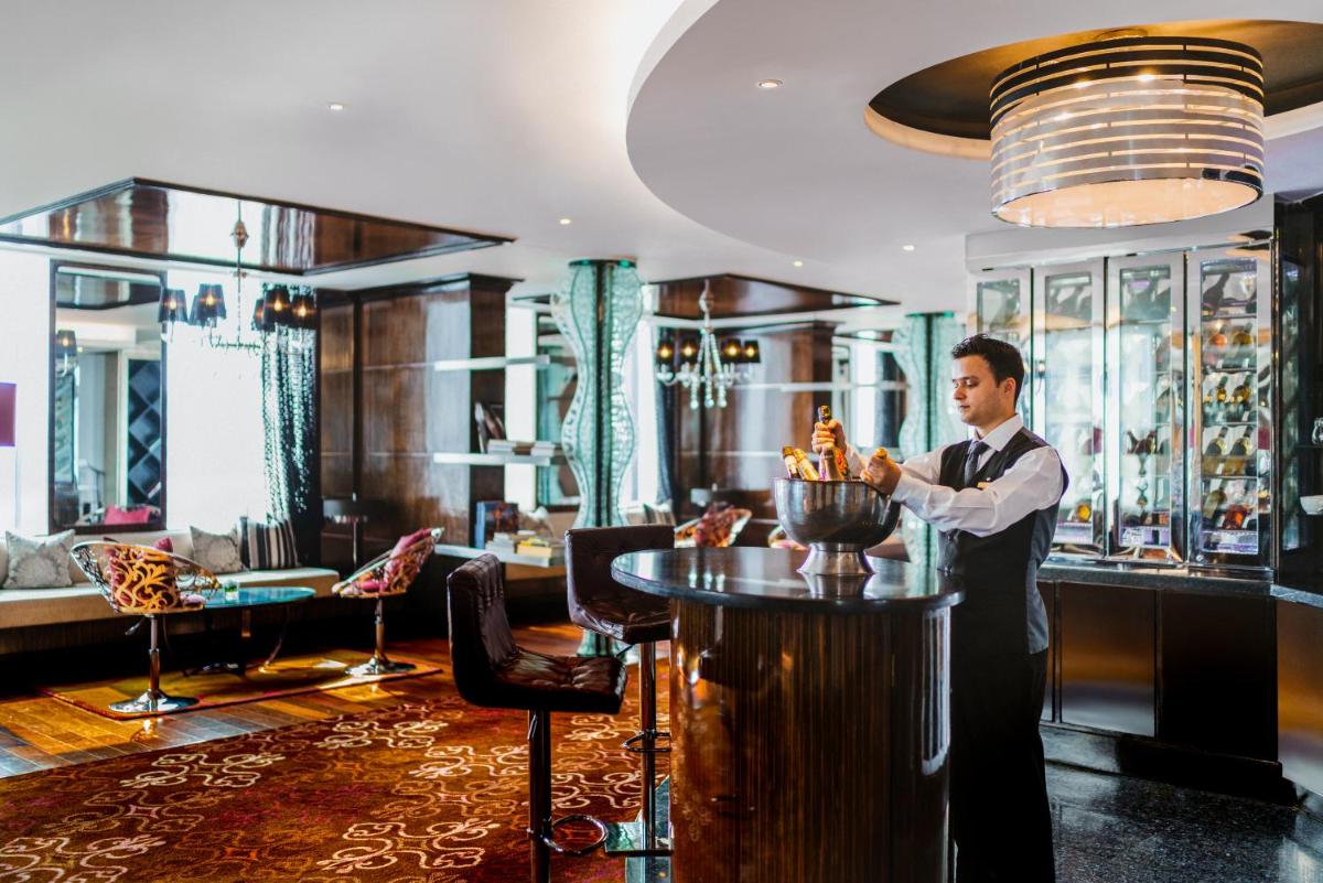 a man standing at a bar in a hotel lobby at Sofitel Mumbai BKC in Mumbai