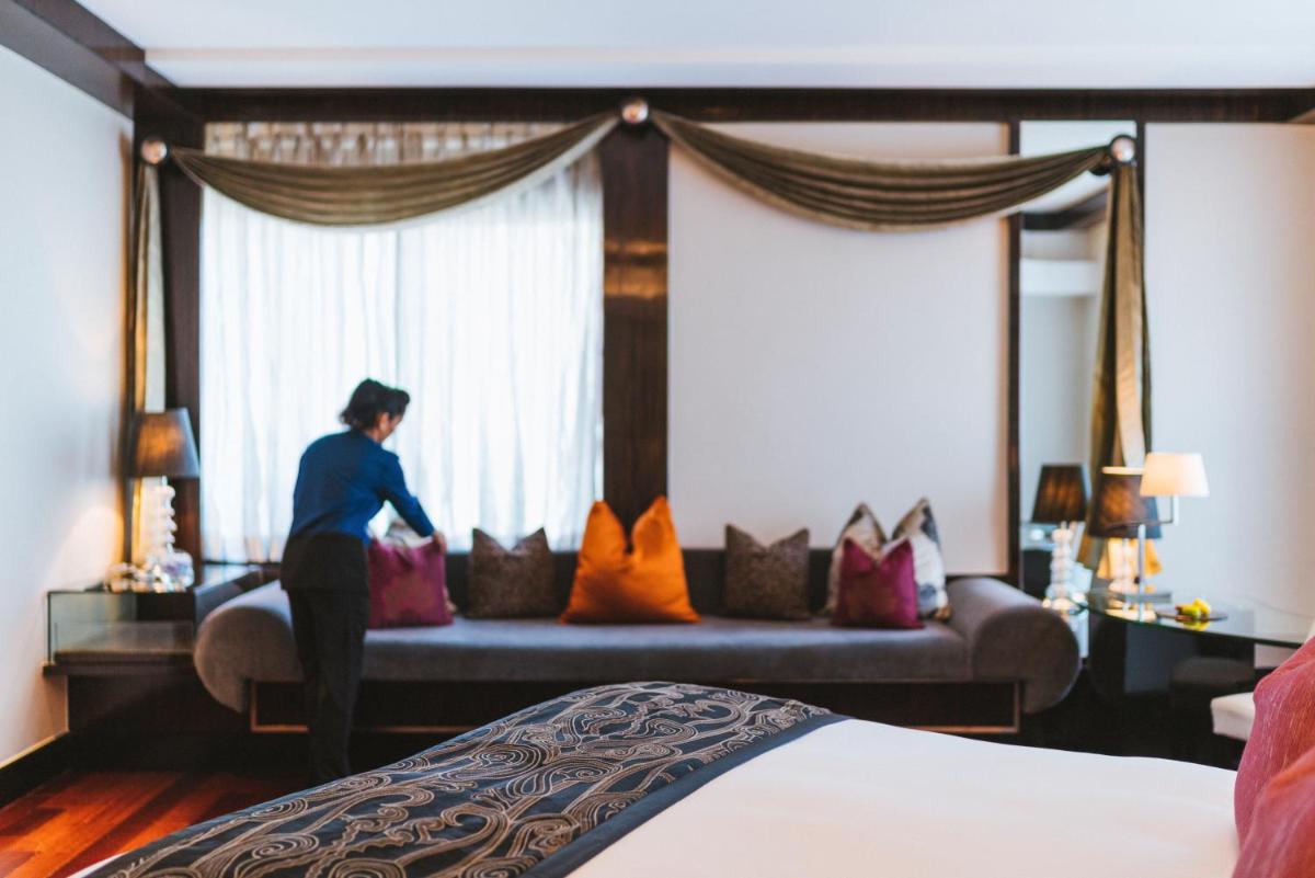 a woman standing in front of a bed in a hotel room at Sofitel Mumbai BKC in Mumbai