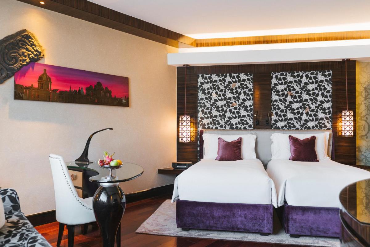a hotel room with two beds and a table at Sofitel Mumbai BKC in Mumbai