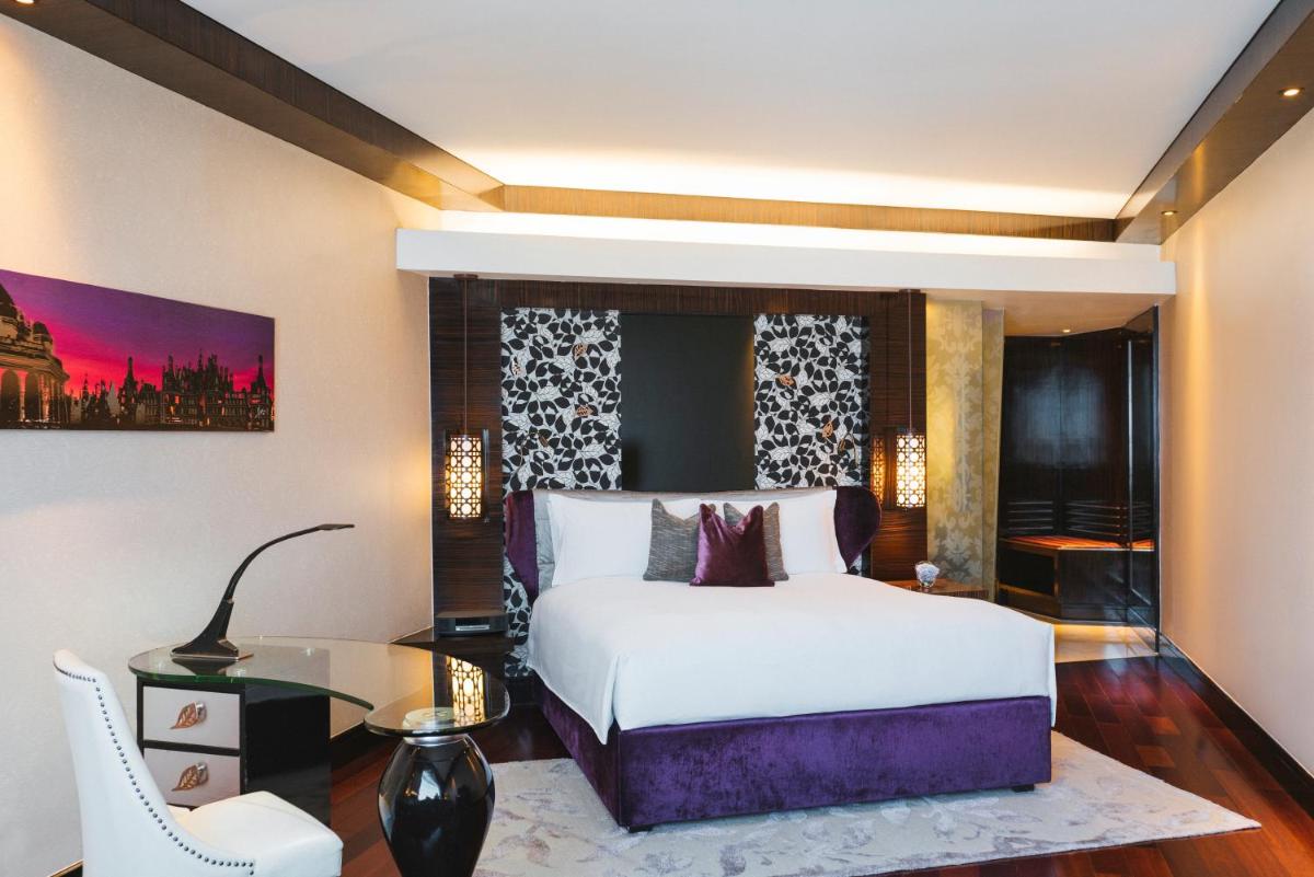 a bedroom with a white bed and a glass table at Sofitel Mumbai BKC in Mumbai