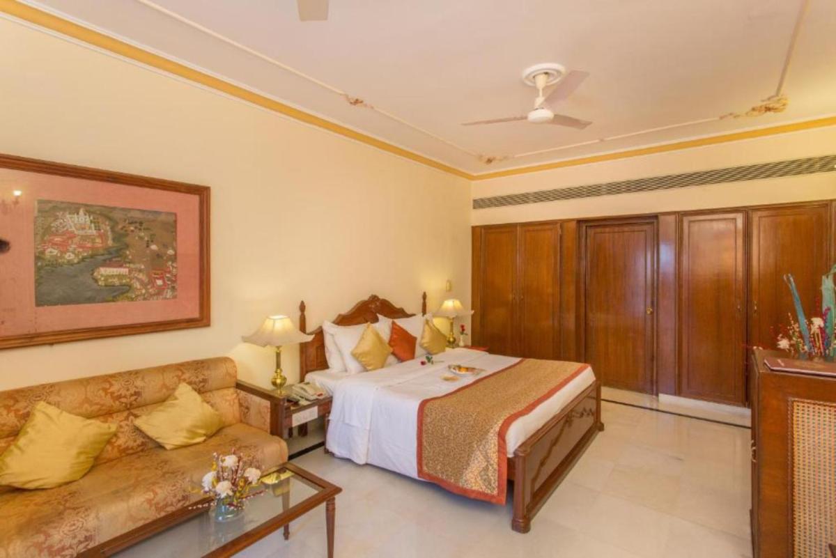 a hotel room with a bed and a couch at Shiv Niwas Palace by HRH Group of Hotels in Udaipur