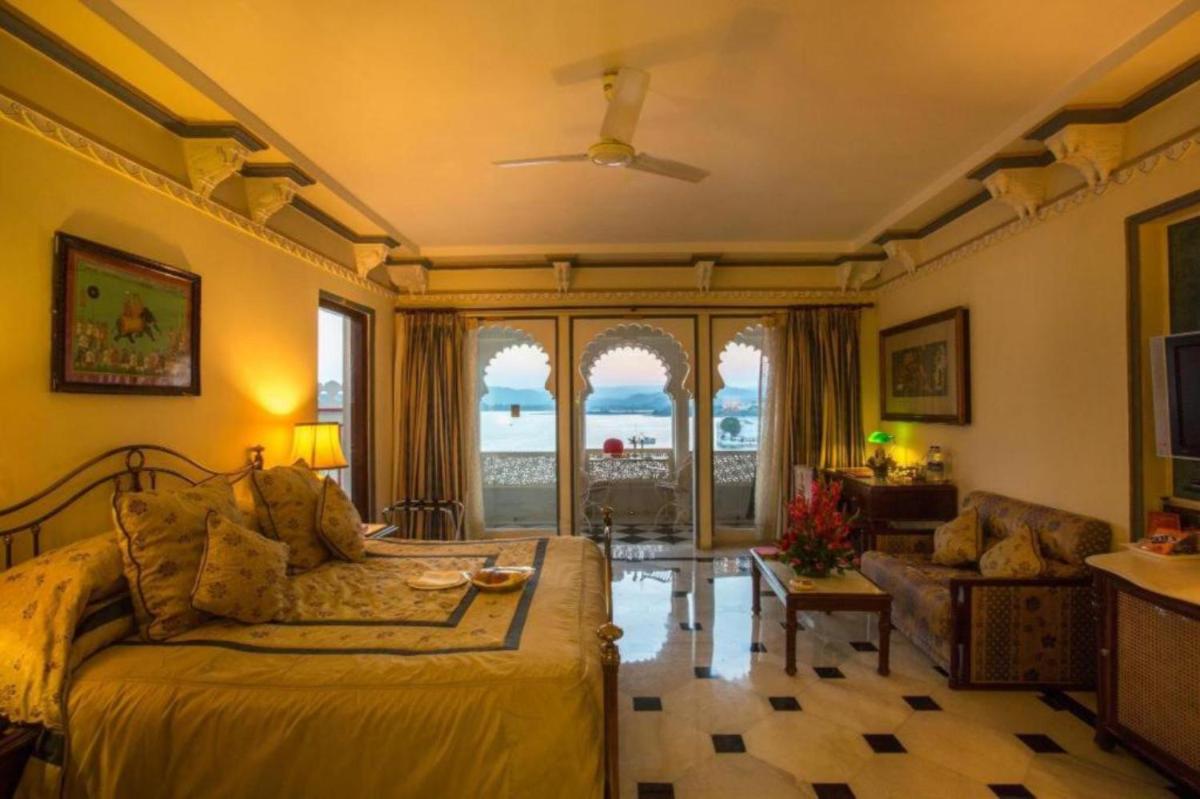 a bedroom with a bed and a living room at Shiv Niwas Palace by HRH Group of Hotels in Udaipur
