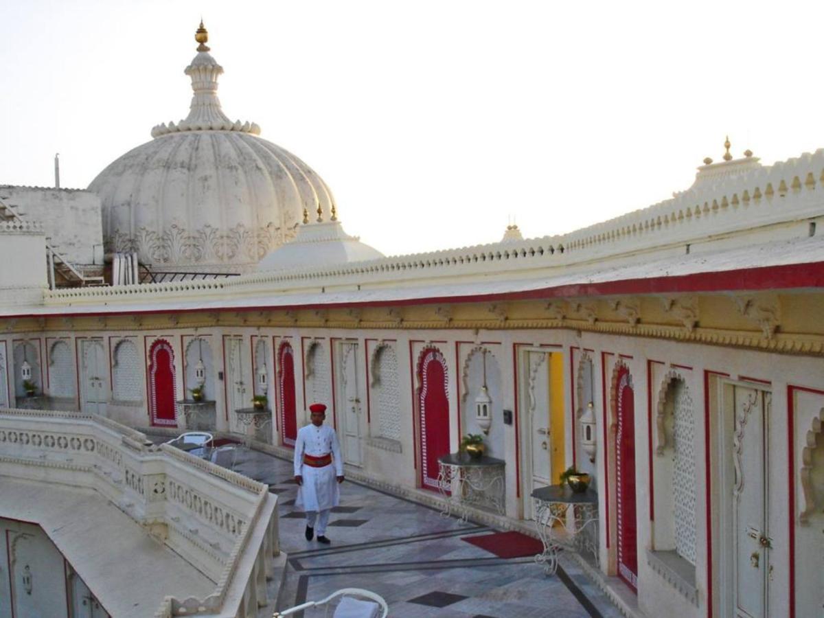 a woman walking in front of a building at Shiv Niwas Palace by HRH Group of Hotels in Udaipur