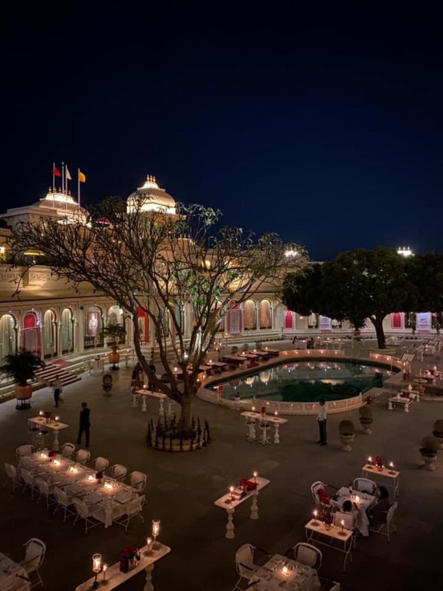 a courtyard with tables and chairs at night at Shiv Niwas Palace by HRH Group of Hotels in Udaipur