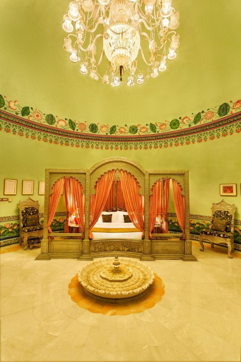 a large room with a bed and a chandelier at Shiv Niwas Palace by HRH Group of Hotels in Udaipur