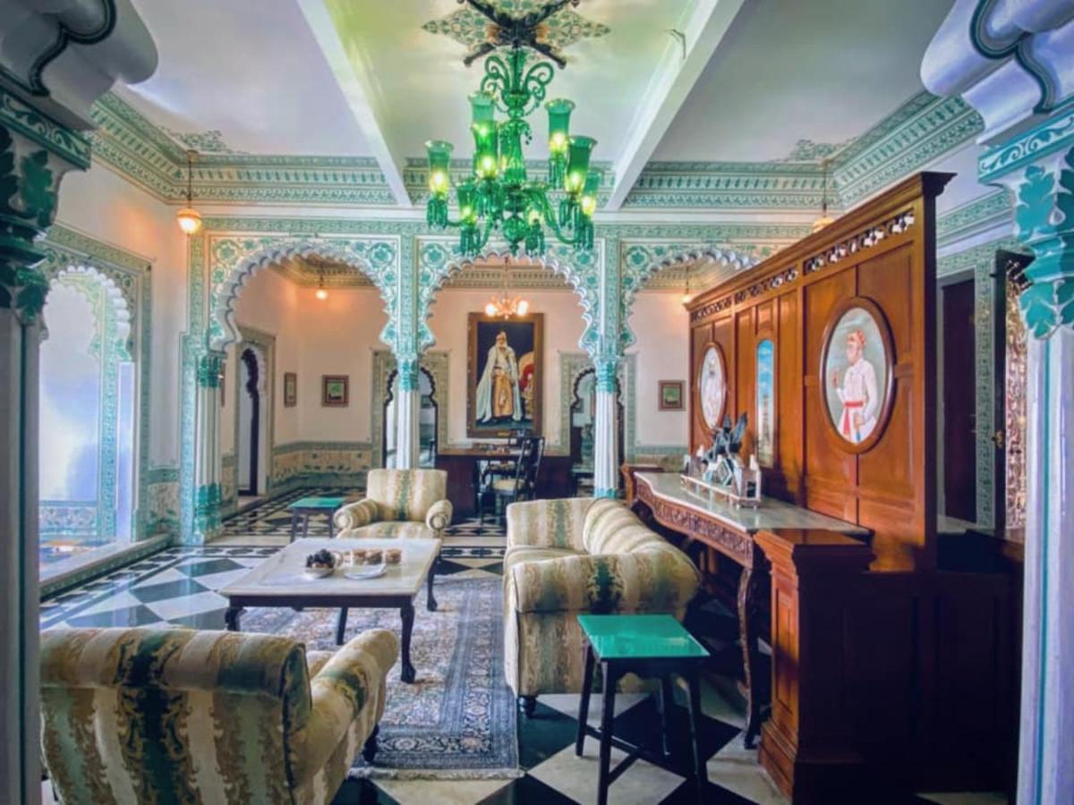 a living room filled with furniture and a chandelier at Shiv Niwas Palace by HRH Group of Hotels in Udaipur