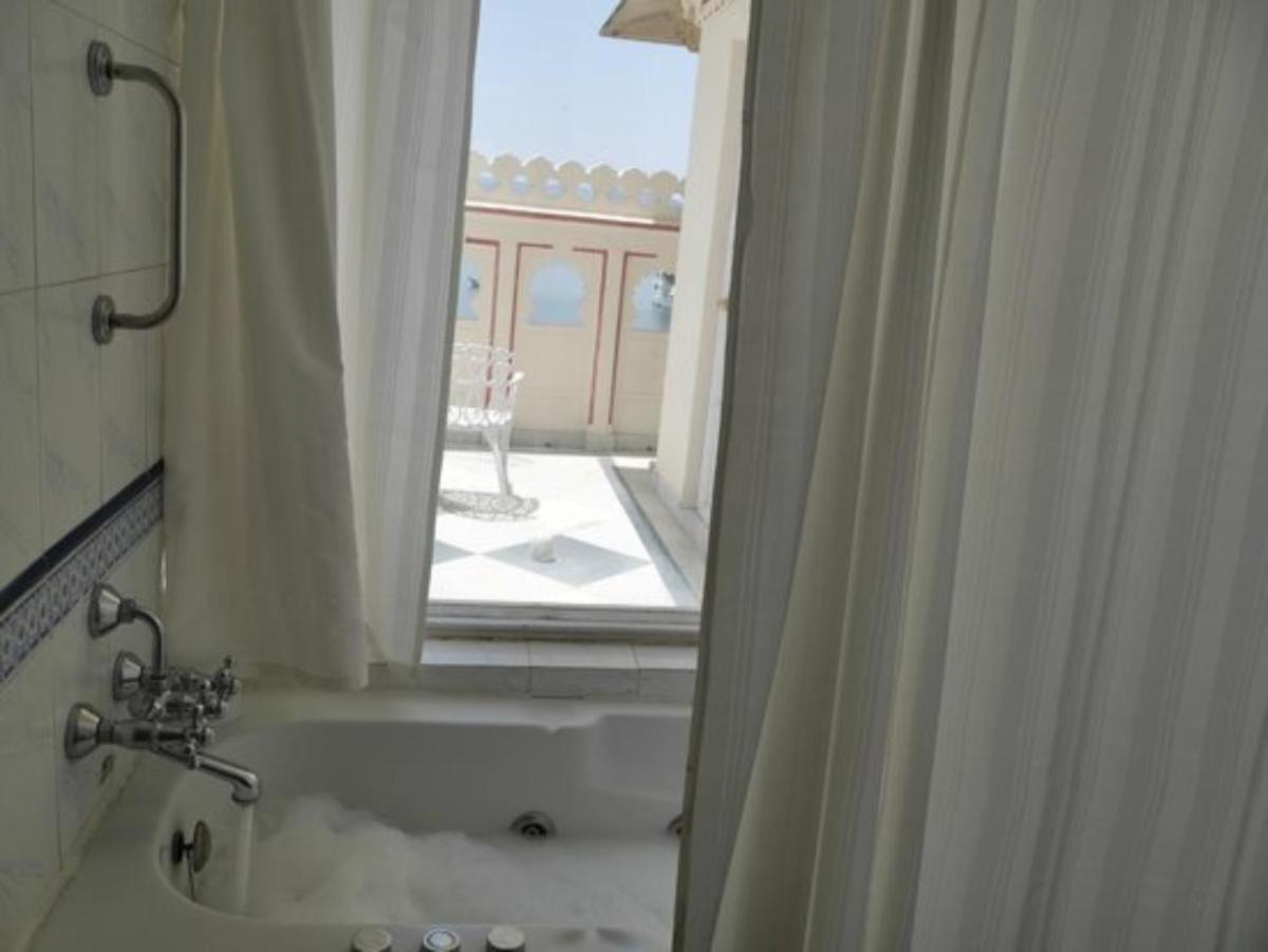 a bathroom with a tub and a window with a view at Shiv Niwas Palace by HRH Group of Hotels in Udaipur