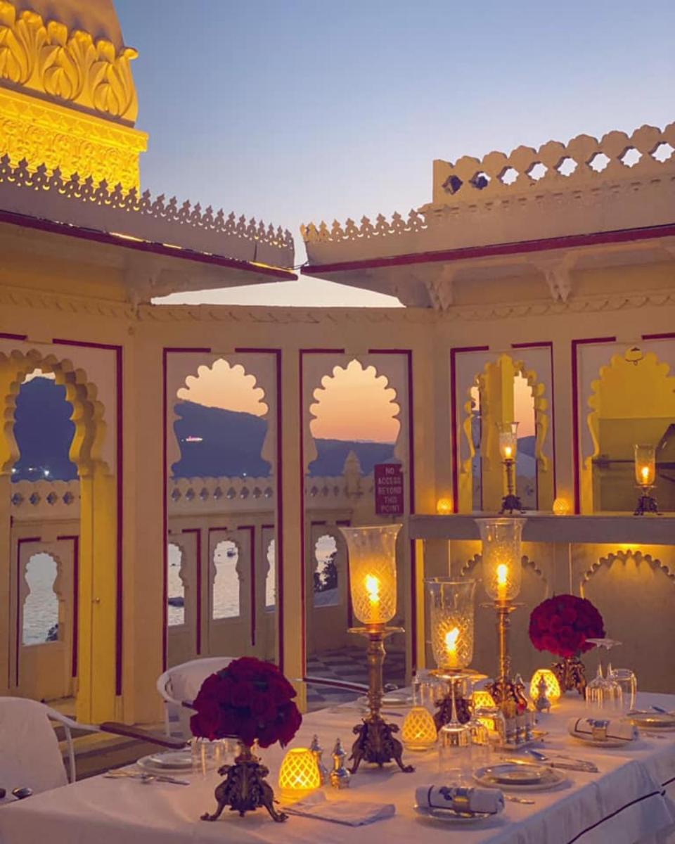 a table with candles and flowers on top at Shiv Niwas Palace by HRH Group of Hotels in Udaipur