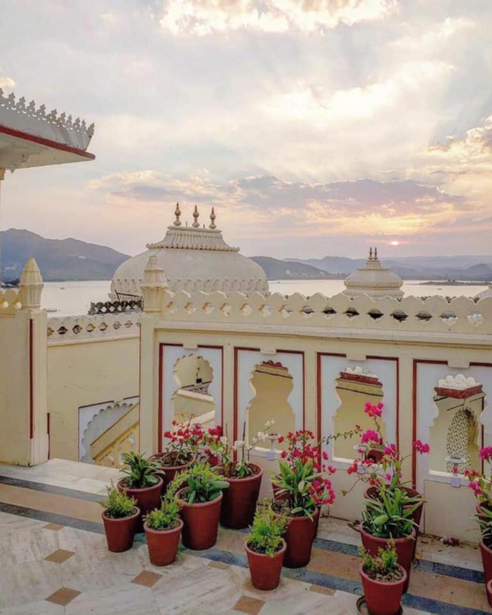 a building with potted plants in front of it at Shiv Niwas Palace by HRH Group of Hotels in Udaipur