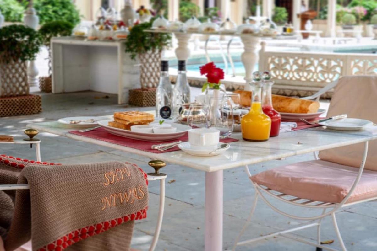 a white table with food and drinks on it at Shiv Niwas Palace by HRH Group of Hotels in Udaipur