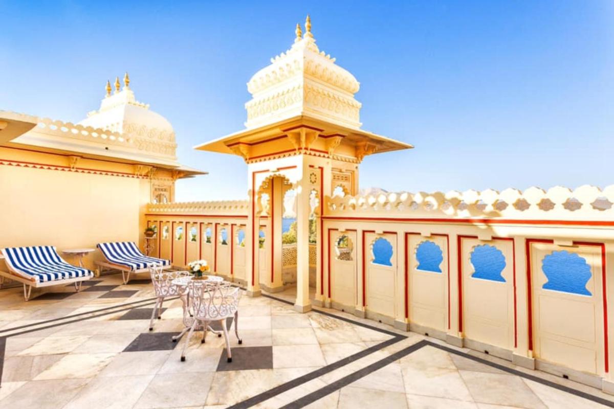 a patio with tables and chairs on a building at Shiv Niwas Palace by HRH Group of Hotels in Udaipur