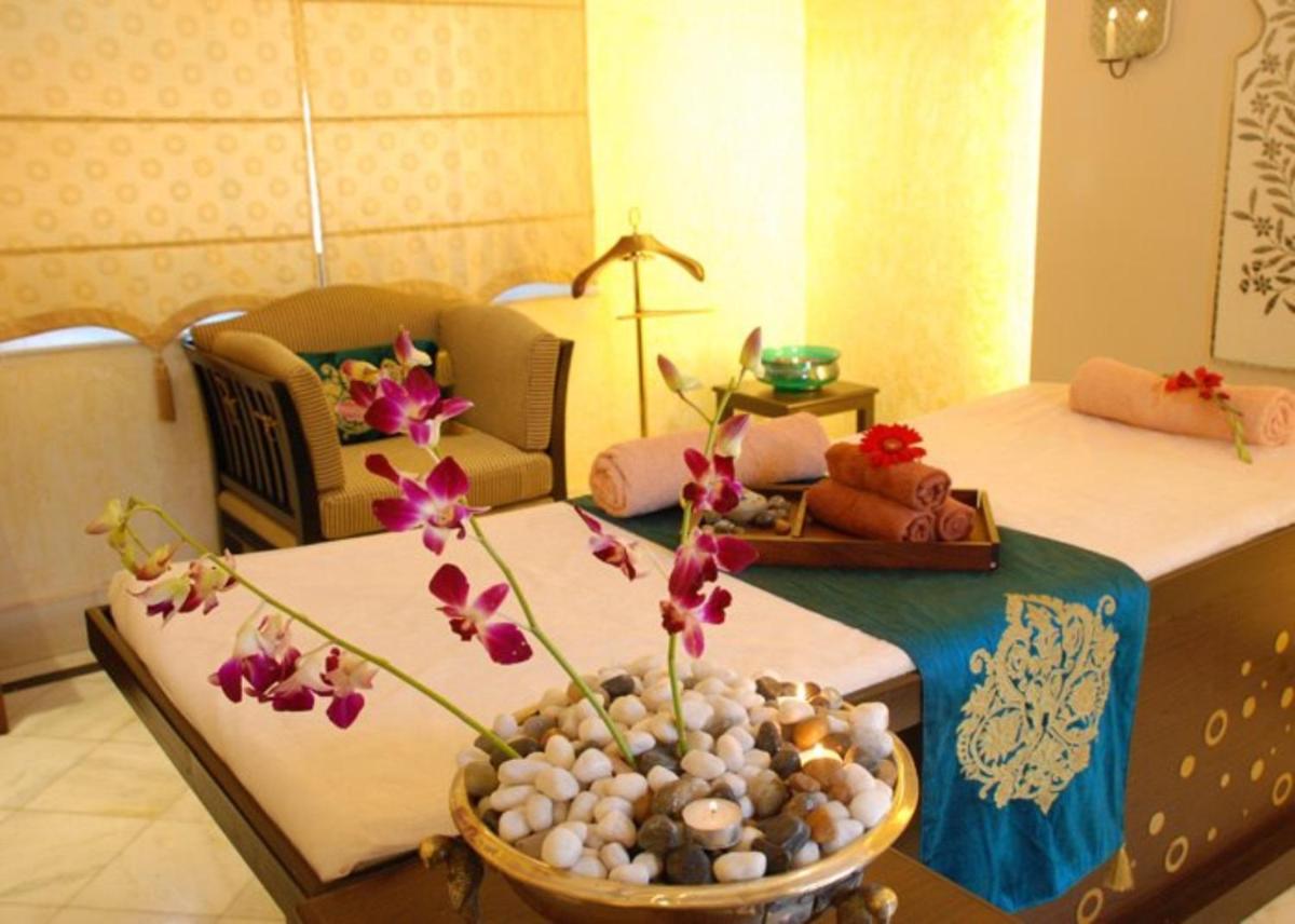 a room with a bed and a vase with flowers at Shiv Niwas Palace by HRH Group of Hotels in Udaipur