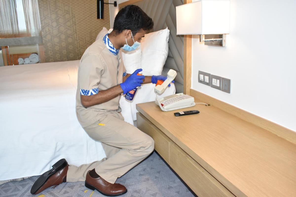 a man in a hotel room with a brush at Welcomhotel by ITC Hotels, RaceCourse, Coimbatore in Coimbatore