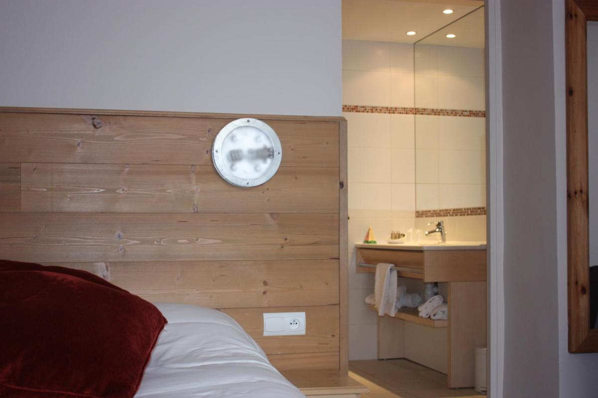 une chambre avec un lit, un lavabo et un miroir dans l'établissement Hotel le Chalet, à Gresse-en-Vercors