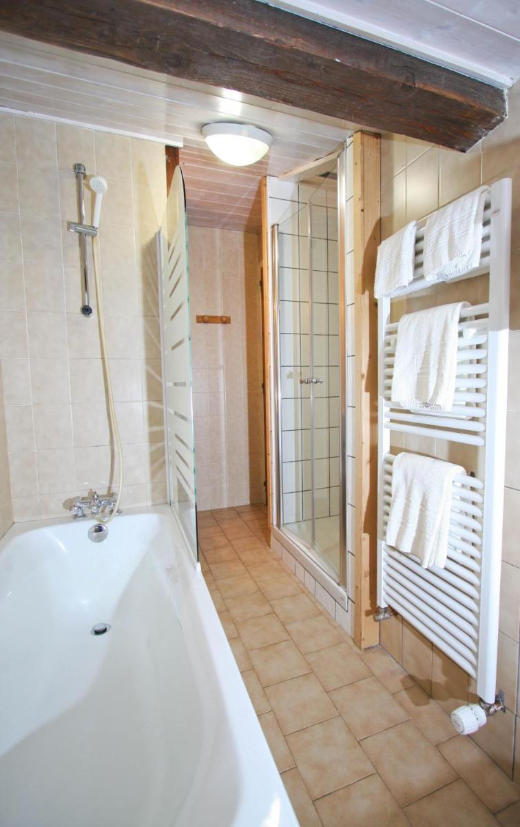 La salle de bains est pourvue d'une baignoire, d'une douche et de serviettes. dans l'établissement Alpen Roc, à Morzine