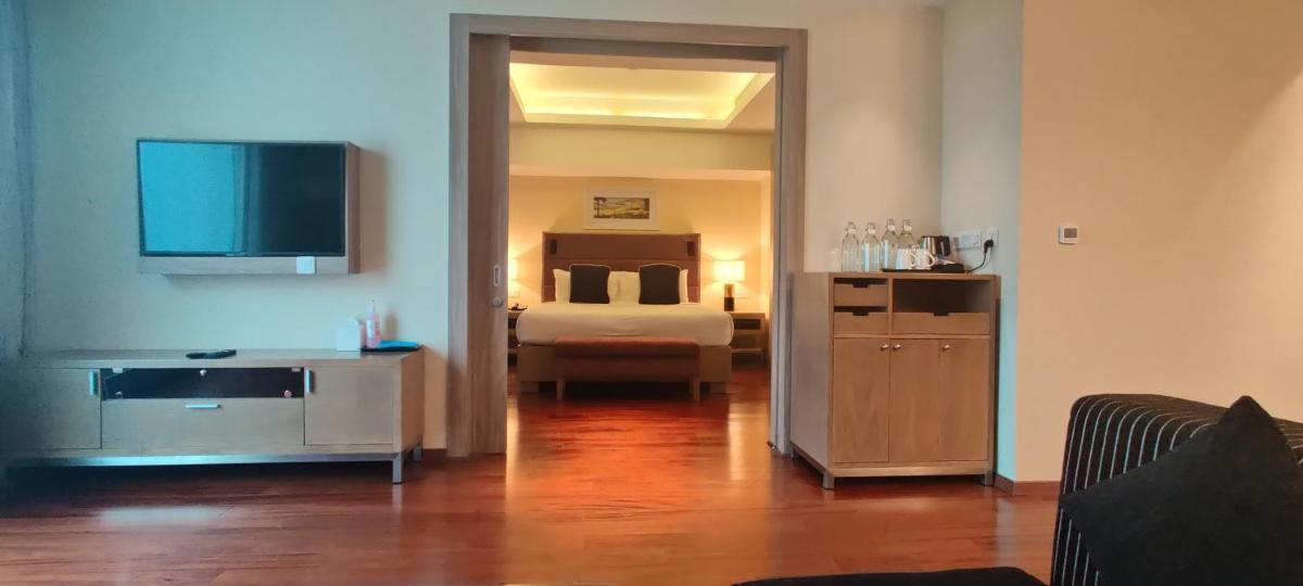 a room with a bedroom with a bed and a television at O by Tamara, Trivandrum in Trivandrum