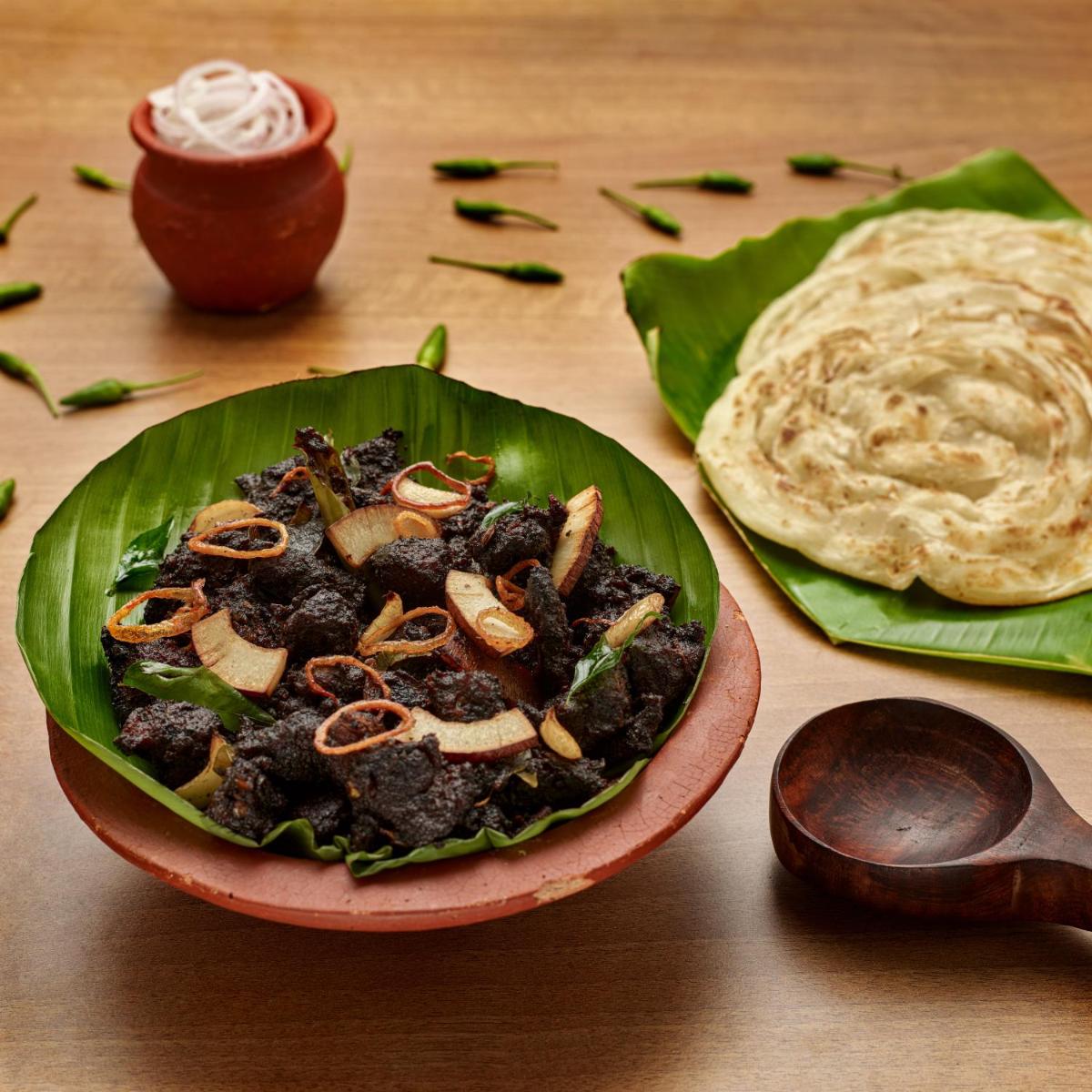 a bowl of food on a table with a plate of food at O by Tamara, Trivandrum in Trivandrum