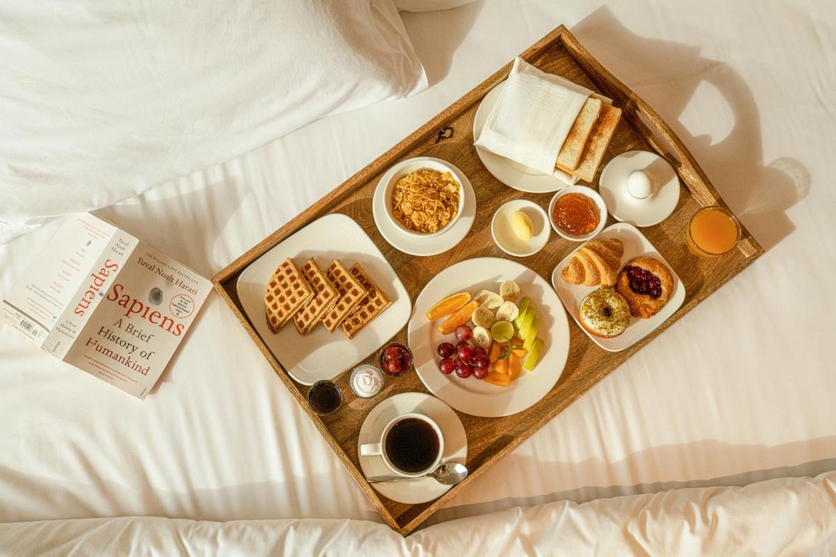 a tray of breakfast foods on a bed at O by Tamara, Trivandrum in Trivandrum