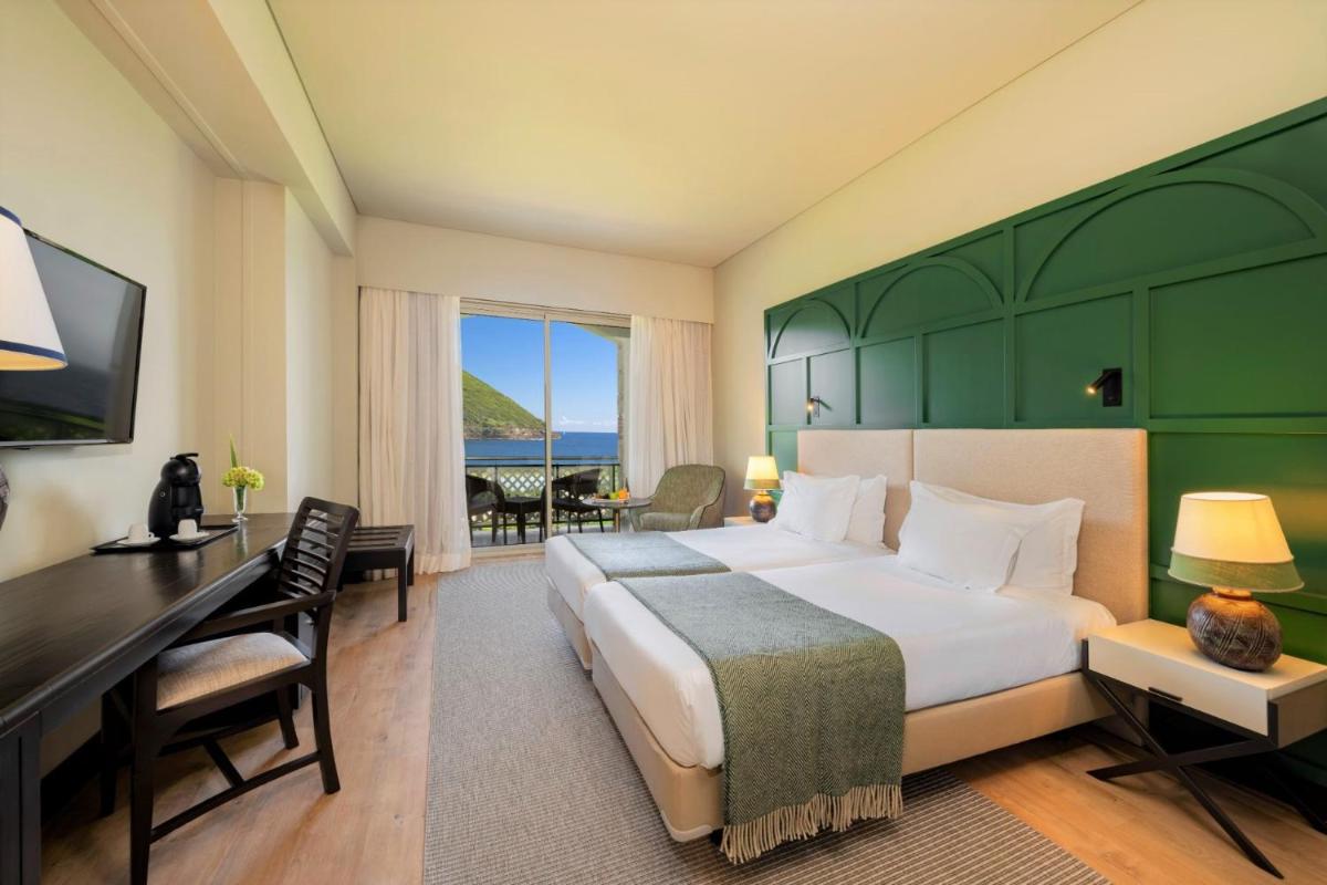 um quarto de hotel com uma cama, uma escrivaninha e um computador em Terceira Mar Hotel em Angra do Heroísmo