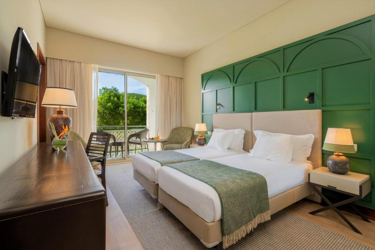 um quarto com uma cama grande com cabeceira verde em Terceira Mar Hotel em Angra do Heroísmo