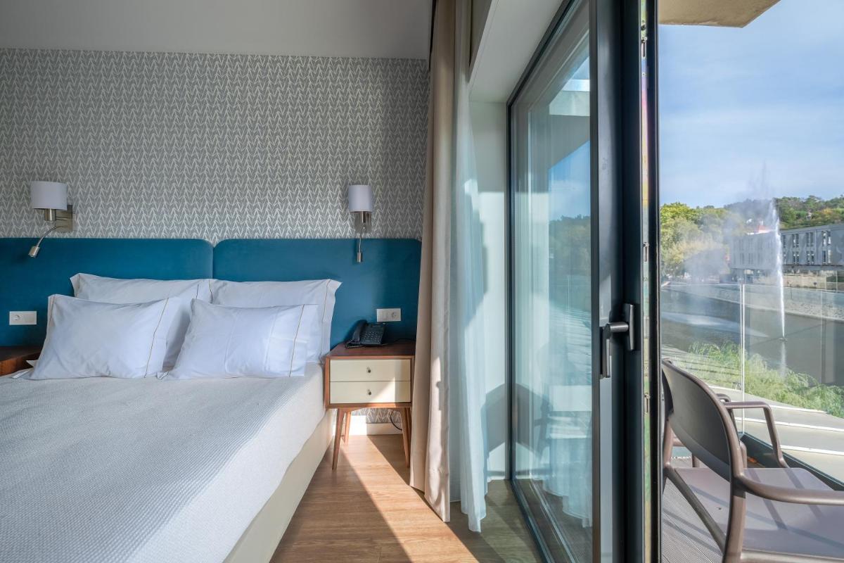 Uma cama ou camas num quarto em Hotel Vouga
