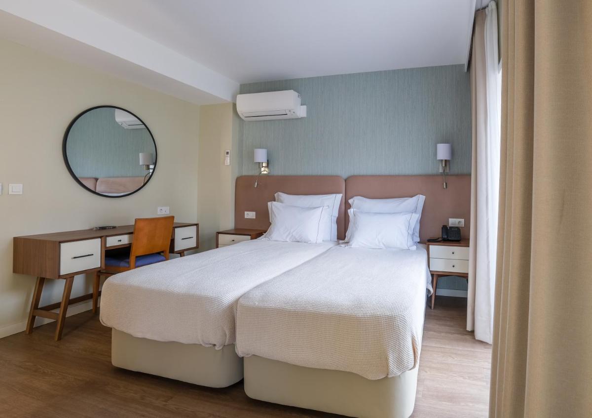 Uma cama ou camas num quarto em Hotel Vouga