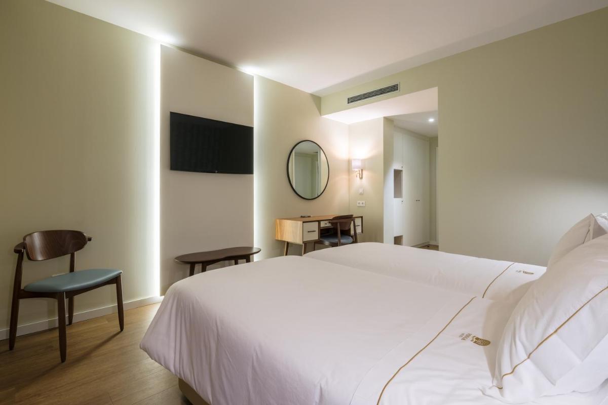 Uma cama ou camas num quarto em Hotel Vouga