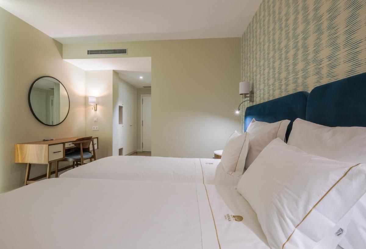 Uma cama ou camas num quarto em Hotel Vouga