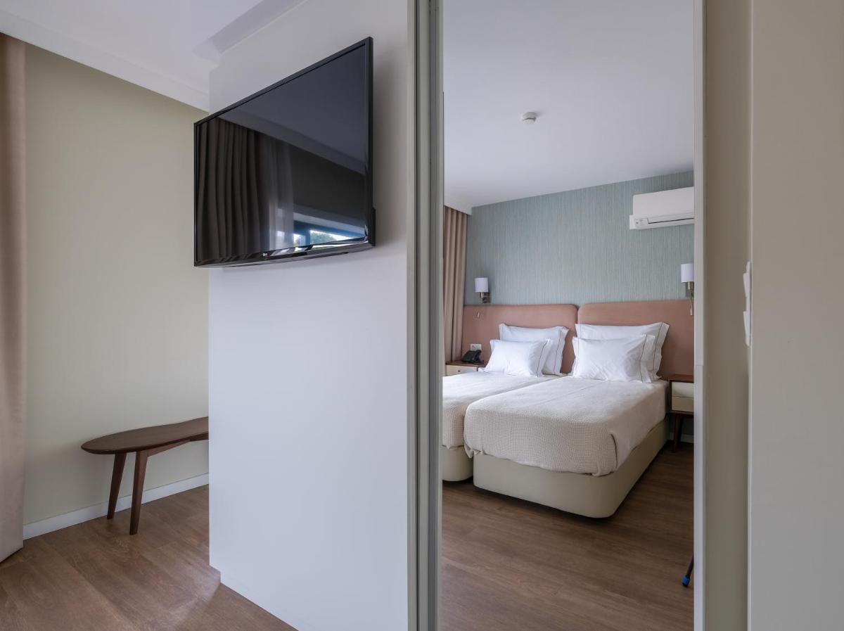 Uma cama ou camas num quarto em Hotel Vouga