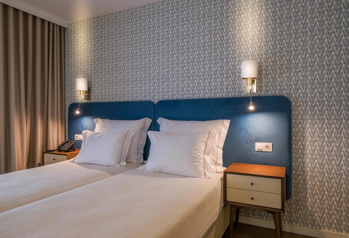 Uma cama ou camas num quarto em Hotel Vouga
