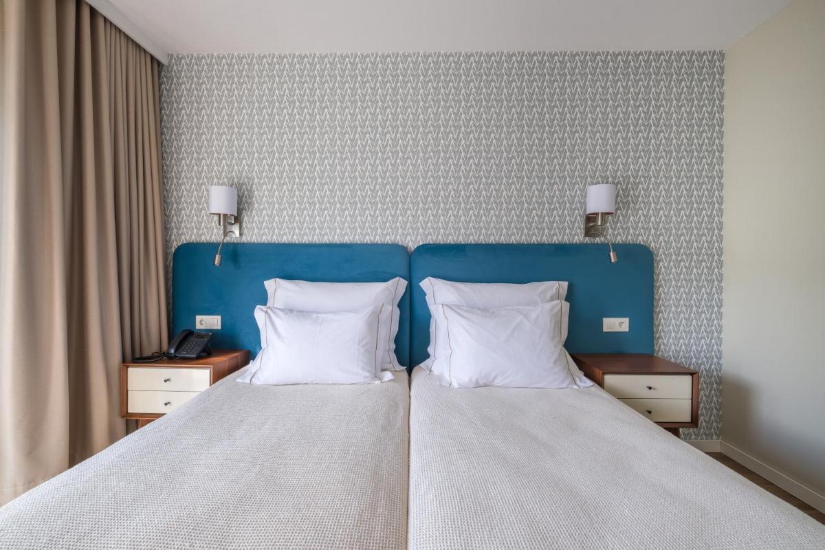 Uma cama ou camas num quarto em Hotel Vouga