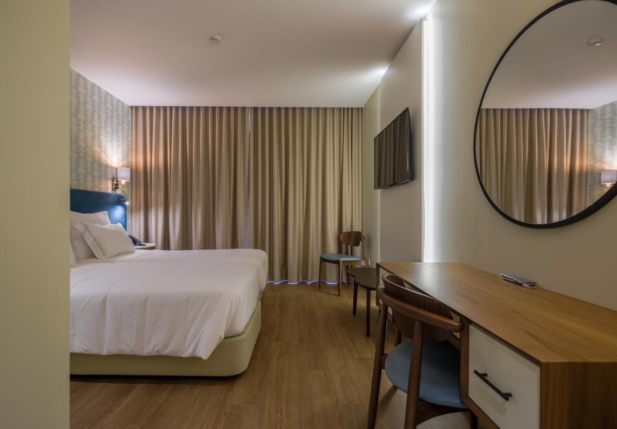 Uma cama ou camas num quarto em Hotel Vouga