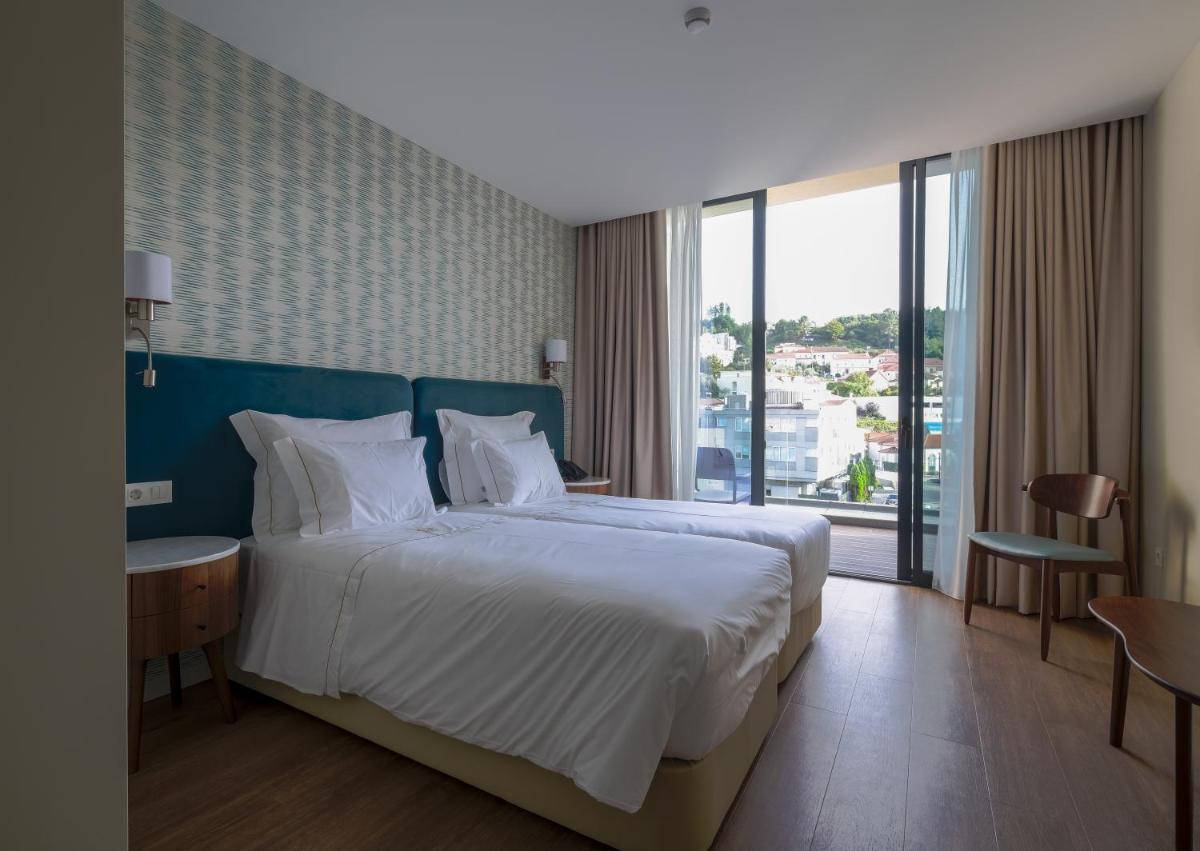 Uma cama ou camas num quarto em Hotel Vouga